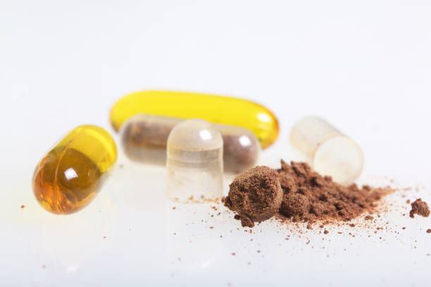 istock The brown pills are scattered over the white surface. One active ingredient is poured from one pill. View from above. 883969660