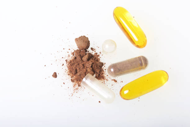 istock The brown pills are scattered over the white surface. One active ingredient is poured from one pill. View from above. 883969698