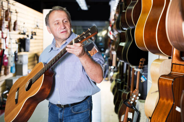 istock Mature man choosing acoustic guitar 883970592