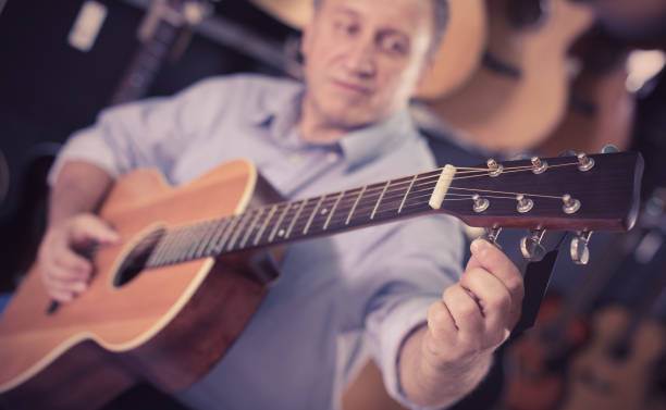 istock music player is playing on acoustic guitar 883970614