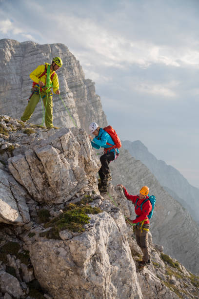 alpinistas subindo uma montanha de rocha - exploration group of people hiking climbing - fotografias e filmes do acervo