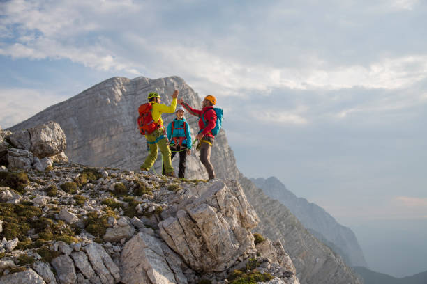 istock Climbers giving high fives on mountain summit 883978038