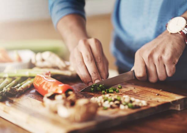 Taking a slice out of the healthy life Cropped shot of a man preparing a healthy meal at home chopping food photos stock pictures, royalty-free photos & images