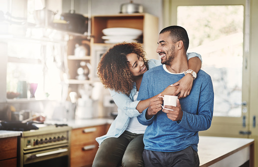 Shot of a happy young couple relaxing in the kitchen in the at home