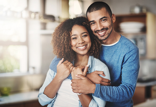 Portrait of a happy young couple in their kitchen at home