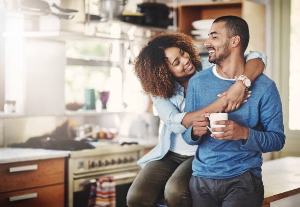 You make me a happy man Shot of a happy young couple relaxing in the kitchen in the at home wife stock pictures, royalty-free photos & images