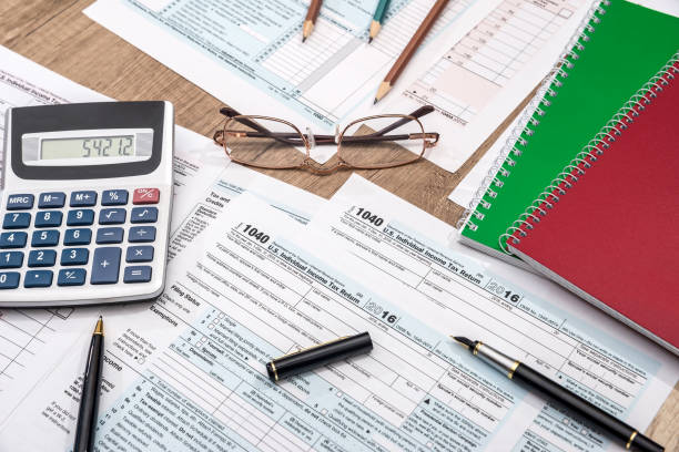 istock tax form with notepad, pen, pencil and calculator 883989834