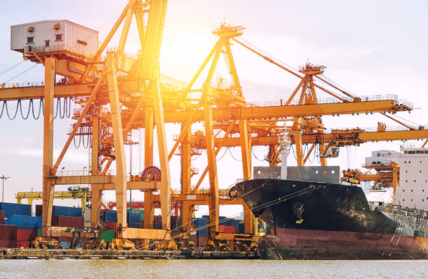 istock Logistics and transportation of container cargo ship with working crane bridge in shipyard at sunrise, logistic import export concept and transport industry concept. 883990998