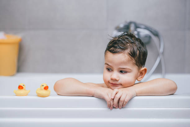boy in the bathtub - bath toy imagens e fotografias de stock