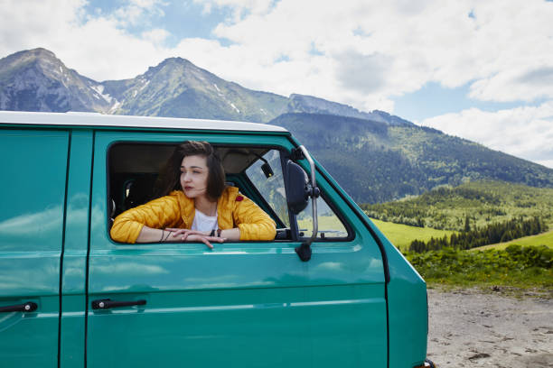 istock Young woman making funny faces. Travelling in a van 884008452