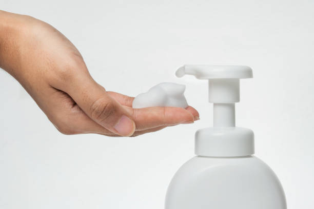 istock Close up Woman hand take cleaner foam from Pure white plastic pump bottle 884011008