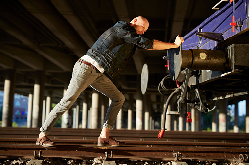 Man pushing the train. Fighting adversities metaphore