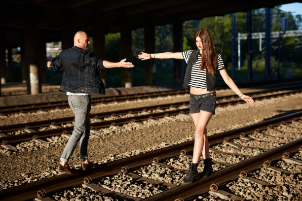 istock Flirty couple walking on a railway tracks 884011736