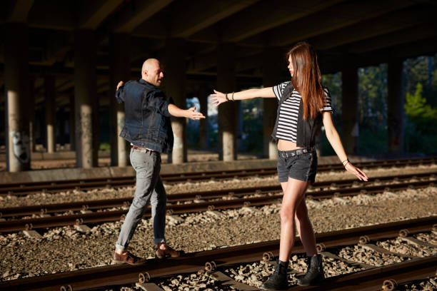 istock Flirty couple walking on a railway tracks 884011800