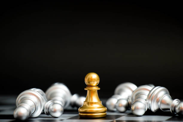istock Gold pawn in chess game face with the another silver team on black background (Concept for company strategy, business victory or decision) 884015408