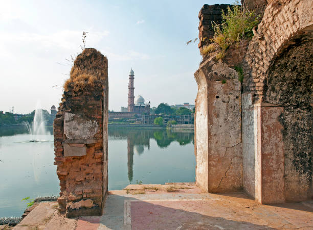 Fountains and faith, Taj-ul Masajid, Bhopal, India Sandstone minaret and domes of the Taj-ul-Masajid, the largest mosque in India, seen across the lake from the Shaukat Mahal ruins, Bhopal, Madhya Pradesh bhopal lake stock pictures, royalty-free photos & images