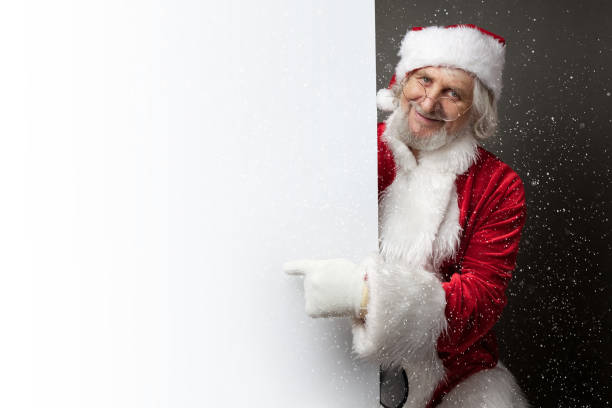 istock Santa Claus showing something on a white wall 884028772
