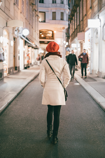 Young fashionable woman walking through vienna downtown and sightseeing in the city at night