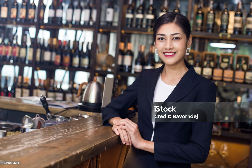 Junge asiatische Frau Restaurant stehend mit glücklich Emotion. Frau anwesend Wein für Kunden in Bar. Frau mit Wein in der Bar-Konzept. - Lizenzfrei Leitende Position Stock-Foto