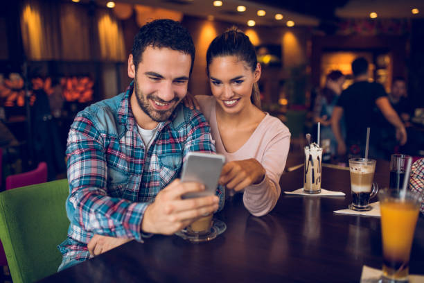 istock Happy couple using mobile phone in cafe. 884039014