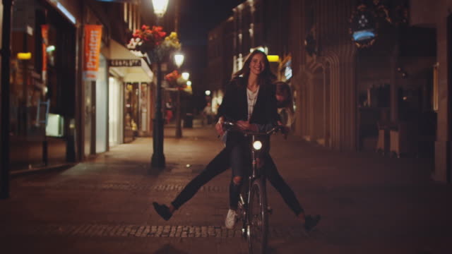 Girls riding bike at night