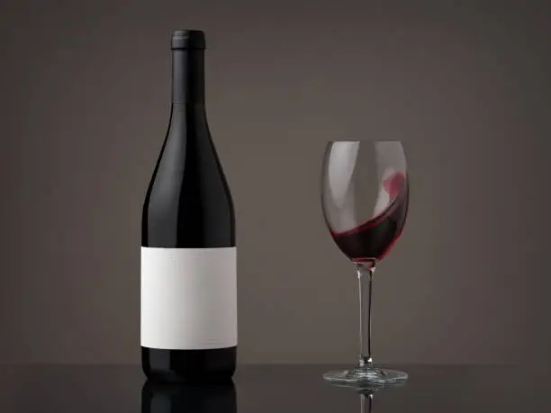 Wine bottle with wineglass. Red wine wave in a glass