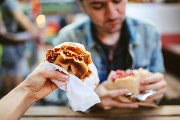 Close up of a Texas pulled pork bbq burger and a falafel outdoors