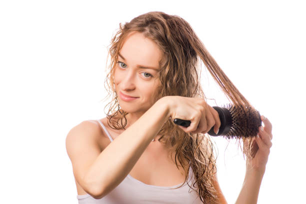istock Beautiful young woman combing her hair 884058312