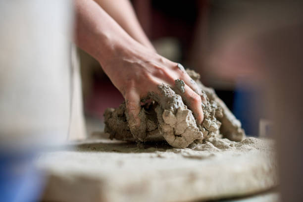 Hands of a potter cultivating clay stock photo