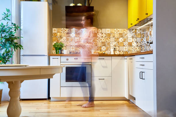 istock Silhouette of a woman walking in her kitchen 884069234