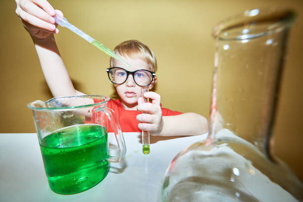 istock Young chemist adding a reagent to the tube with a pipette 884069330