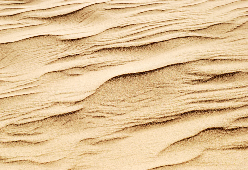 Wind formed beautiful temporary sand pattern in the desert. The sand looks like frozen waves.