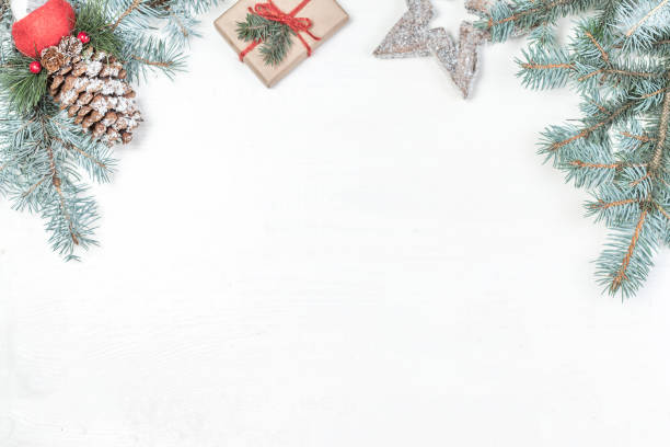 istock Christmas background with holiday decoration elements, presents  and fir tree branches on white wooden background. Christmas Flat lay  and top view composition with border and empty copy space 