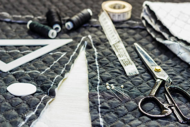 istock Workplace tailor. On the table close-up lie the samples of fabrics, scissors, thread, balac, roulette and buttons. 884076246