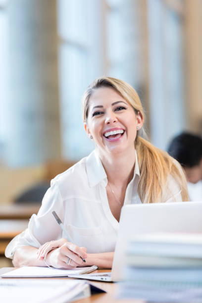 istock Happy adult student laughs while studying with a friend 884083418