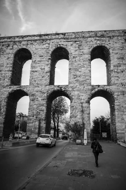 Istanbul, Turkey - November 14, 2017: Cars drive through arches at Valens Aqueduct on Atatürk Boulevard in Istanbul, Turkey. Completed in the late 4th century AD by Roman Emperor Valens, it was maintained and used by the Byzantines and later the Ottomans.