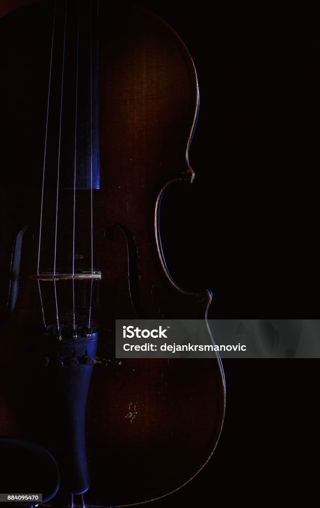 Violin in Dark Accentuated shapes of violin with light, illuminated in dark. Aging Process Stock Photo