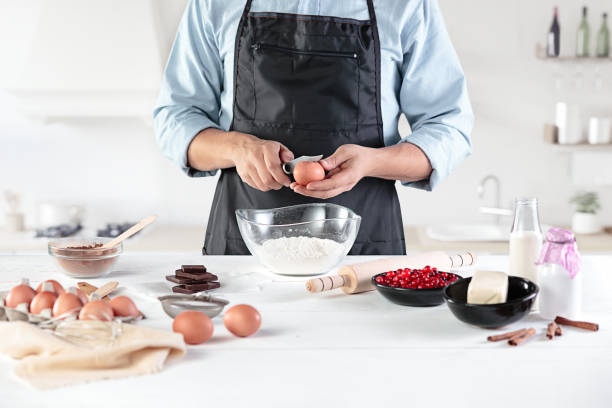istock A cook with eggs on a rustic kitchen against the background of men's hands 884099002