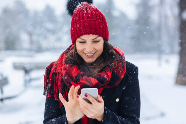 Pretty girl using cellphone in snow
