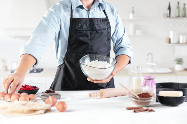 istock A cook with eggs on a rustic kitchen against the background of men's hands 884116698