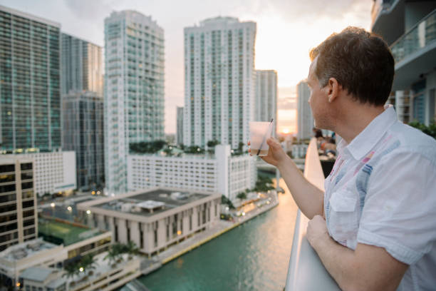 istock Mature Man Drinking with View of Downtown Miami Brickell Buildings 884119054