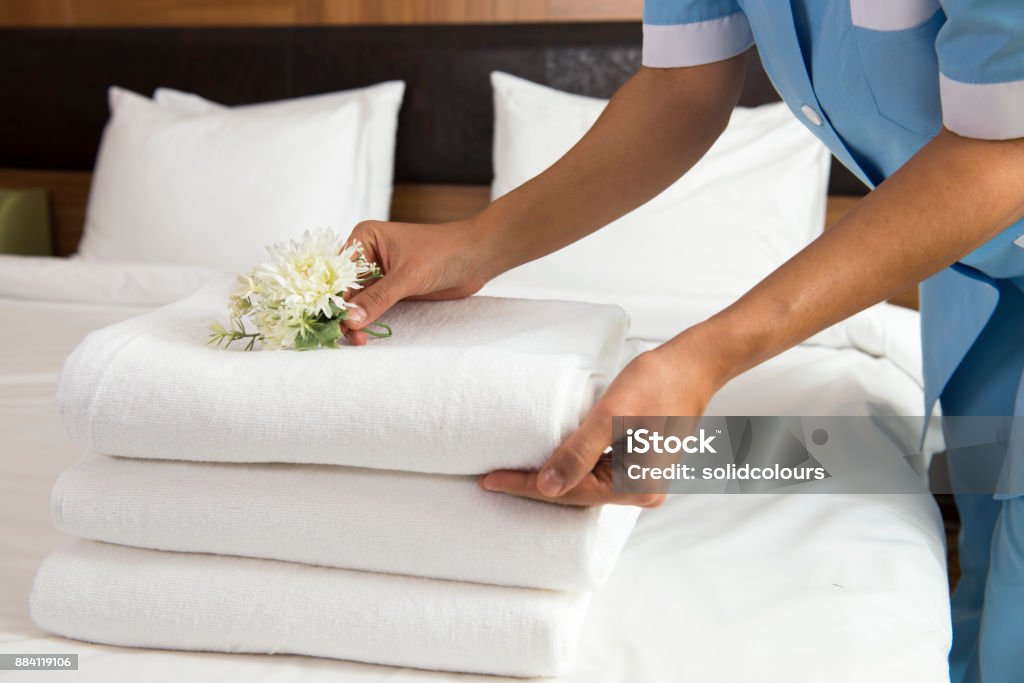 Chambermaid Making Bed Maid making bed in hotel room. She is  Hotel Stock Photo