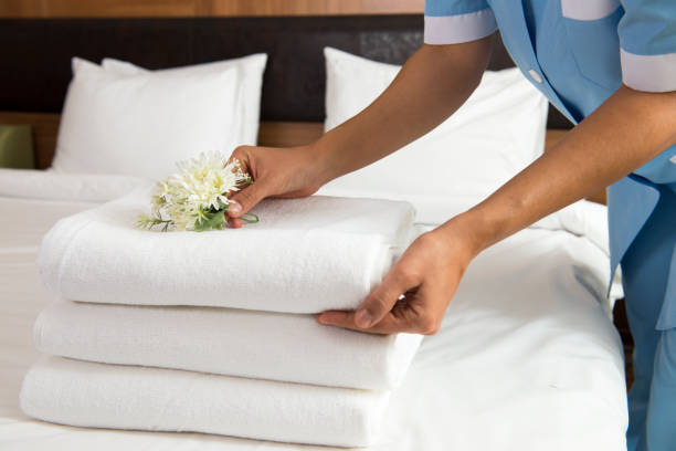 Chambermaid Making Bed Maid making bed in hotel room. She is  room service stock pictures, royalty-free photos & images