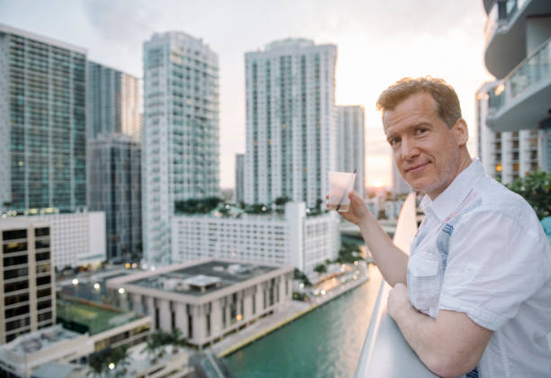 istock Mature Man Drinking with View of Downtown Miami Brickell Buildings 884119236