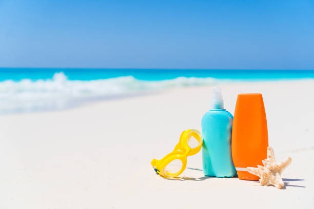 istock Suncream bottles, goggles, starfish on white sand beach background ocean 884122574