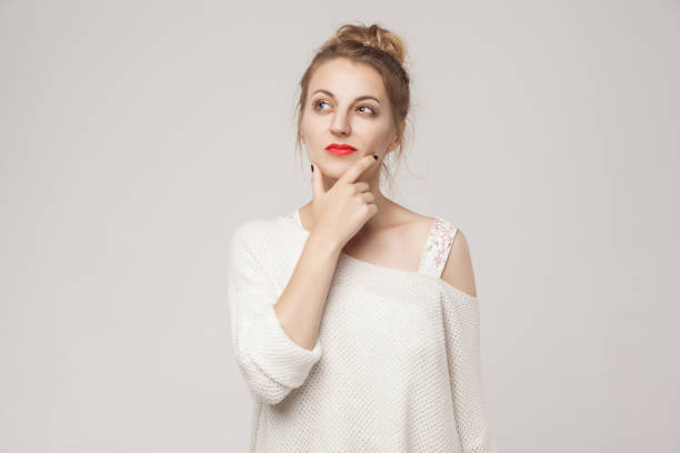istock Thoughtful woman touching chin, thinking and looking up . 884148478