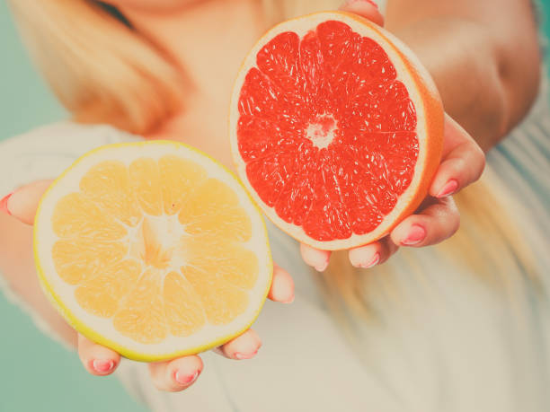 istock Woman holding red and green grapefruit 884151864
