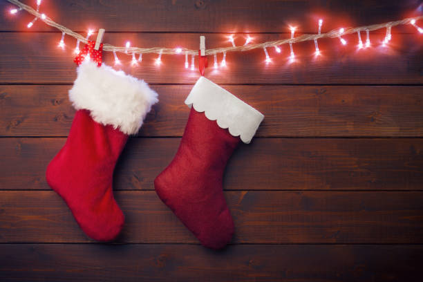 istock Two Santa socks hanging on glowing garland 884155022