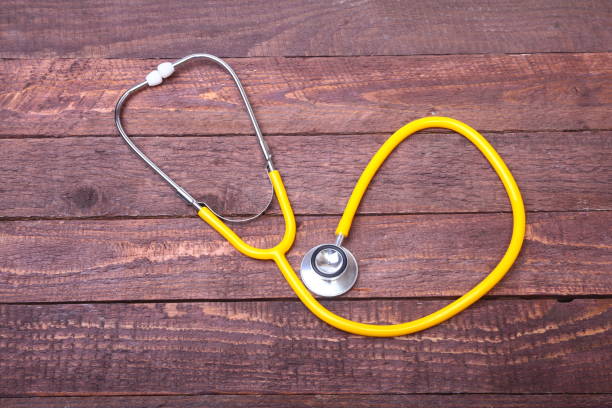 istock Medical stethoscope and tablets isolated on wooden background 884155610