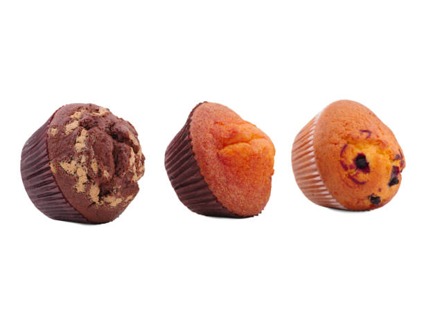 istock Three cupcakes with different fillings, lying on their side, isolated on white background 884164454